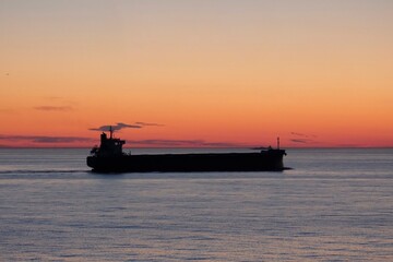 Obraz premium Cargo ship in the Baltic sea during beautiful sunrise.