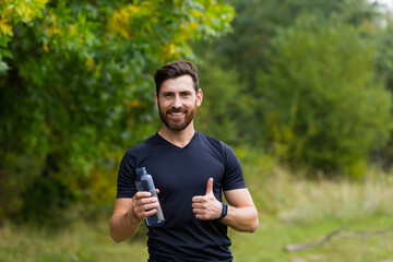 Tired exhausted dehydrated Athlete man runner drinking water bottle after workout. Sports bottle drink. male sportsman. runner sweaty and thirsty after difficult jogging outdoors in city park