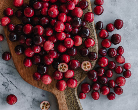 Fresh cranberries on a wooden chopping board