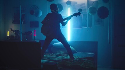 Cool teenager playing guitar in bedroom