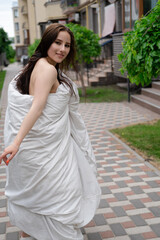 pretty brunette woman in white blanket outdoors. crazy rebel millennial girl