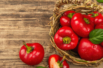 Ripe red round peppers in a handmade wicker basket