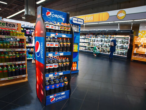 Minsk, Belarus. Feb 2021. Pepsi slim rack suited to various Pepsi bottles. Pepsico bottles on the stand in the supermarket. Showcase with PepsiCo soft drinks.