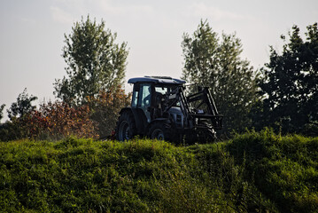 Traktor , lamborghini ,  na wzgórzu podczas prac polowych . Tractor on the hill during field work.  - obrazy, fototapety, plakaty