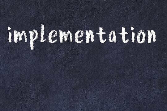 College chalk desk with the word implementation written on in