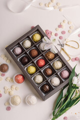 Set of healthy handmade chocolate candies in box and flowers. Cheese truffles. Sweet gift for Woman's Day, birthday or Mother's Day. Set of 15 candies