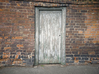 Oude deur in oude bakstenen muur