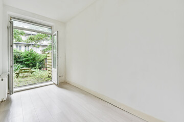 Beautiful image of an empty room with an excess to the garden area in a white interior design house
