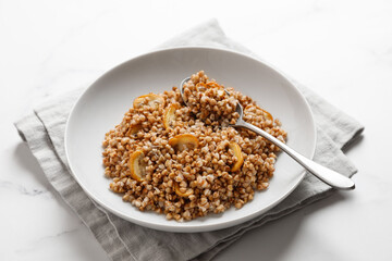 boiled buckwheat porridge with mushrooms with a spoon on napkin