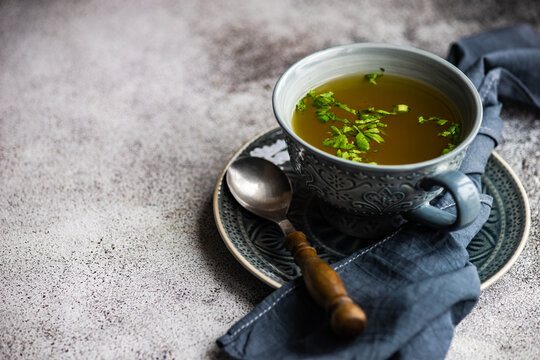 Bowl of healthy chicken broth with parsley