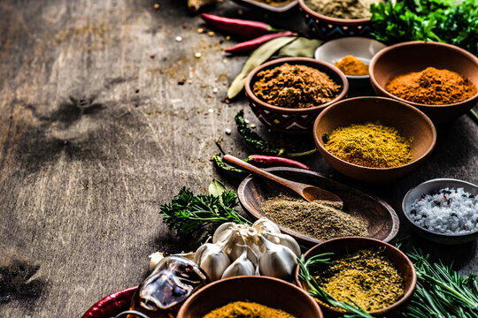 Arrangement of assorted fresh and dried herbs and spices on a wooden table