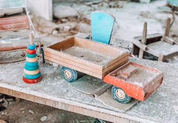 Children's toys covered with dust and debris in the ruins of an abandoned house. 