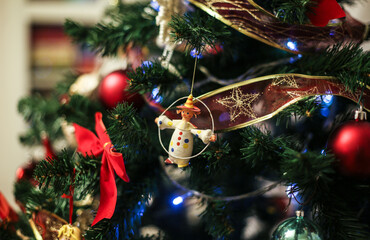 Vintage retro Christmas papier mache toy of funny clown hanging on beautiful decorated New Year fir tree.