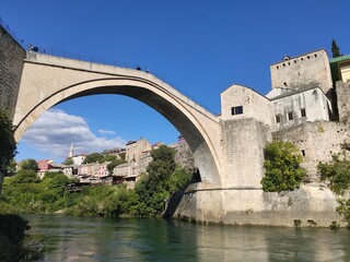 Fototapeta na wymiar La village de Mostar en Bosnie-Herzégovine, avec ses maisons, pierres et son vieux pont, sur les bords du fleuve Neretva, ancienne province Ottoman