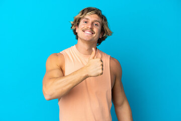 Handsome blonde man isolated on blue background giving a thumbs up gesture