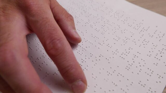 Blind Men Is Reading a Braille Text From a Paper With His Fingers