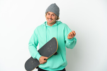 Young skater blonde man isolated on white background making money gesture © luismolinero
