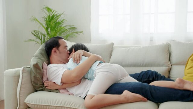 Asian Family Relations , Boy hugging his father and sleeping on the sofa
