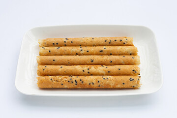 Crispy egg rolls in plate on white background.