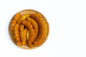 Tamarind pickled fermented in bamboo basket on white background.
