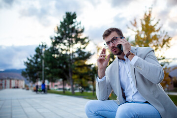 Businessman sitting outside and talking on phone