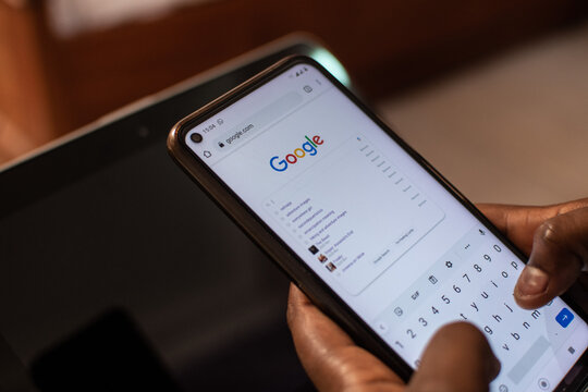 Auchi, Edo-Nigeria-June 12, 2021: black person using google to do a search