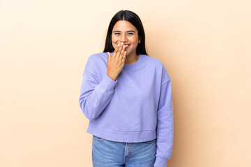 Young latin woman woman over isolated background happy and smiling covering mouth with hand