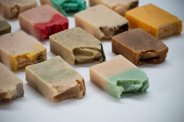 Detail shot of a variety of handmade soaps on white background.