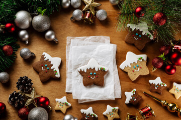 Sweet Christmas Gingerbread Star Cookies decorated with royal icing on a Empty Paper on a wood table, top view, Christmas Celebration mood