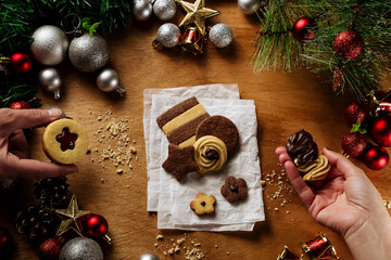 Hands pick up Butter Cookies on a Christmas Celebration mood wood table, top view