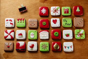 Advent Calendar Sweet Christmas Gingerbread Cookies decorated with royal icing on a wood table, top...