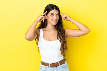 Young caucasian woman isolated on yellow background having doubts and thinking