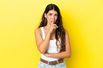 Young caucasian woman isolated on yellow background showing a sign of silence gesture putting finger in mouth