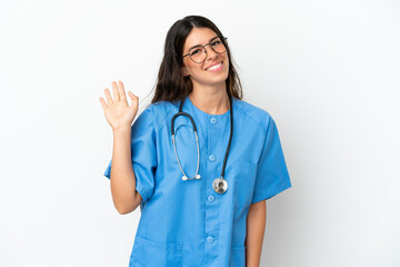 Young surgeon doctor caucasian woman isolated on white background saluting with hand with happy expression