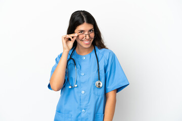 Young surgeon doctor caucasian woman isolated on white background with glasses and happy