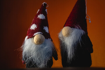 Two red Christmas elves (elf) with red pointy caps and white beards. Christmas scene. Snowing cold Santa helpers. Cute red elves