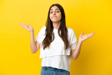 Young caucasian woman isolated on yellow background making doubts gesture