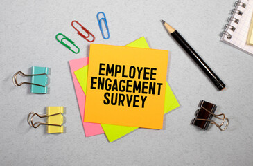Employee Engagement Survey sign written on sticky note pinned on wooden wall.