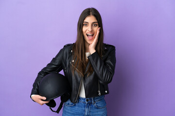 Young caucasian woman with a motorcycle helmet isolated on purple background with surprise and shocked facial expression