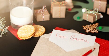 Naklejka na ściany i meble A letter to Santa on the table with cookies and milk