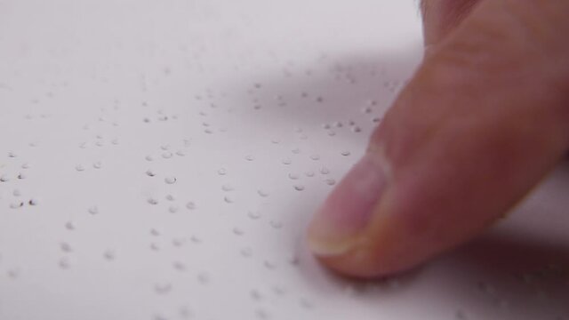 Closeup Finger of a Blind Person Reading Braille Text