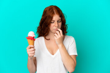 Teenager reddish woman with a cornet ice cream isolated on blue background having doubts