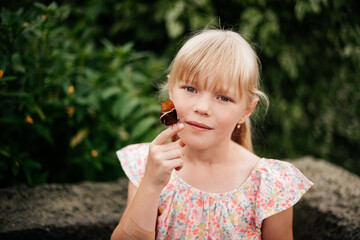 portrait of a little blonde girl with a lively beautiful butterfly, amazing nature, happy childhood.