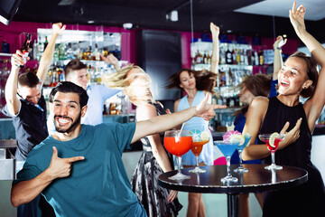 Happy smiling man with young female are enjoying the party in bar.