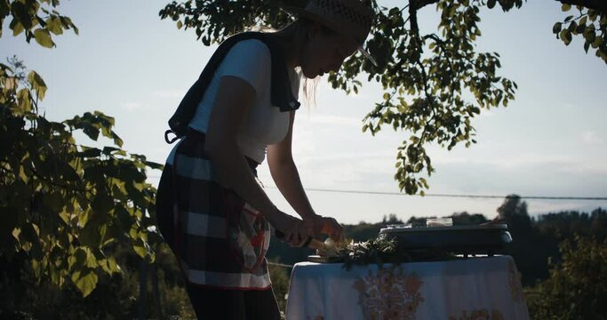 Woman knife in hands cut onion cooking evening sun light lens flares
