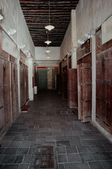 A corridor full of shops with old wooden doors with metal hinges inside Souq Waqif in Qatar 