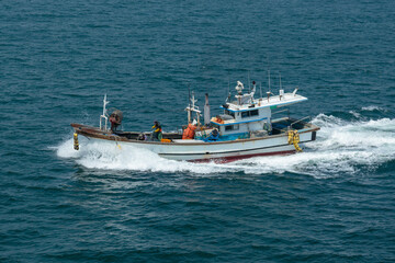 Naklejka premium The fishing vessel moves to the sea.