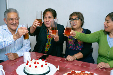 An older man with his friends celebrating a birthday at an indoor party. old birthday