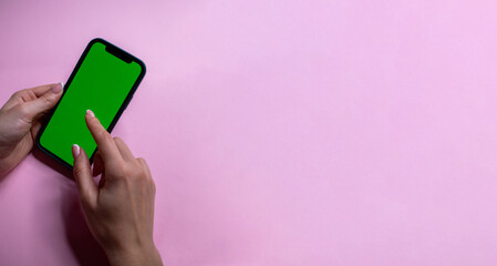 phone in female hands with a green screen for chroma key

