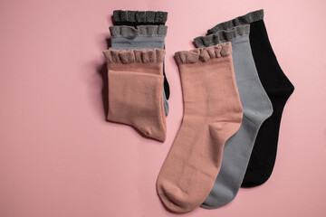 beautiful socks on a pink background, place for text
